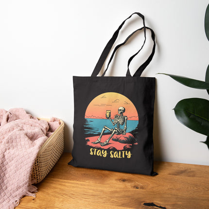 Stay Salty Canvas Tote Bag, Skeleton Relaxing on the Beach, Perfect for shopping & gifting. Sunset, funky, playful, sassy, shoulder bag.